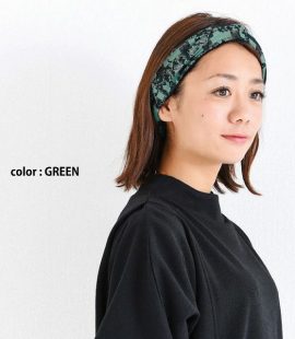 緑色のAvant gardeオーガニックタックターバンヘアバンドをかぶる女性